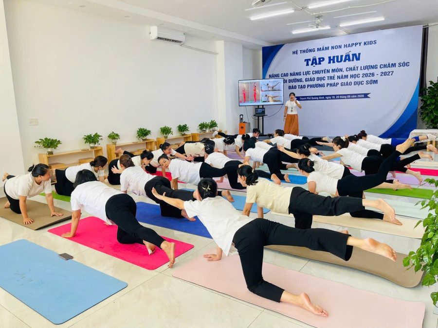 Cả lớp giáo viên tập tư thế chú chó duỗi chân
