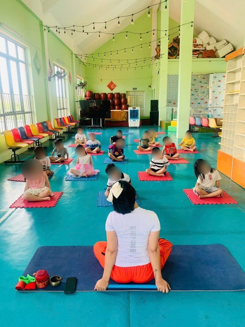 Các bé mầm non ngồi thiền trên thảm cùng cô Sophia