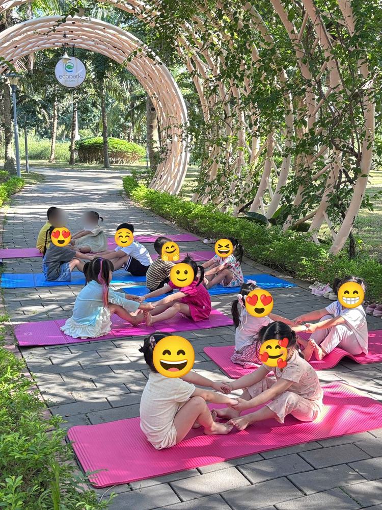 Các cặp bé nắm tay kéo giãn dưới vòm cây Ecopark