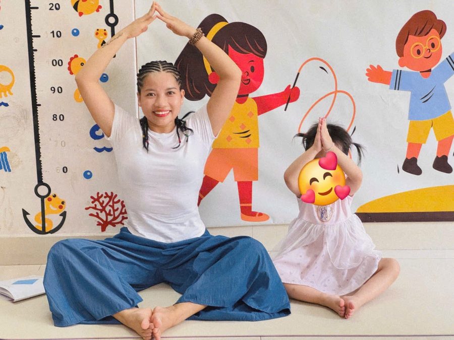 Cô Sophia cười cùng một bé gái chắp tay